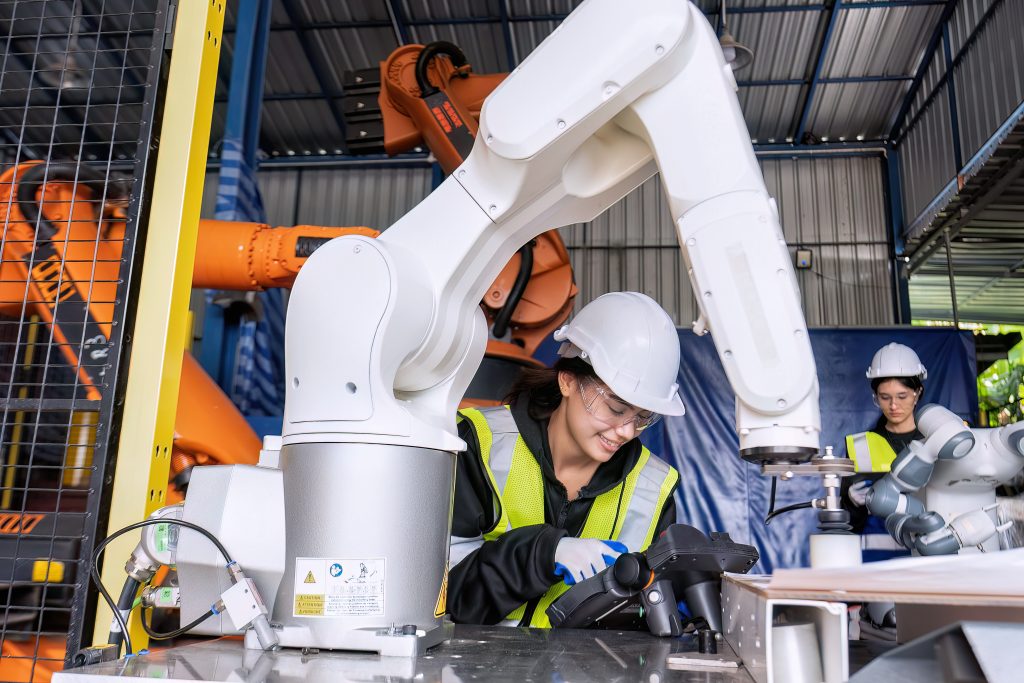 service-engineer-holding-a-robot-controller-operates-a-robotic-arm-automation-factory